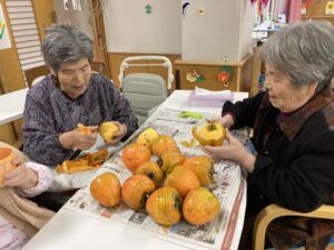 ショート利用者が柿の皮むきを手伝ってくれて、
皮をむいた柿を天日干ししている。